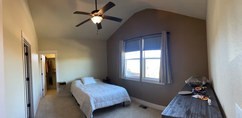Bedroom with brown accent wall and vaulted ceiling