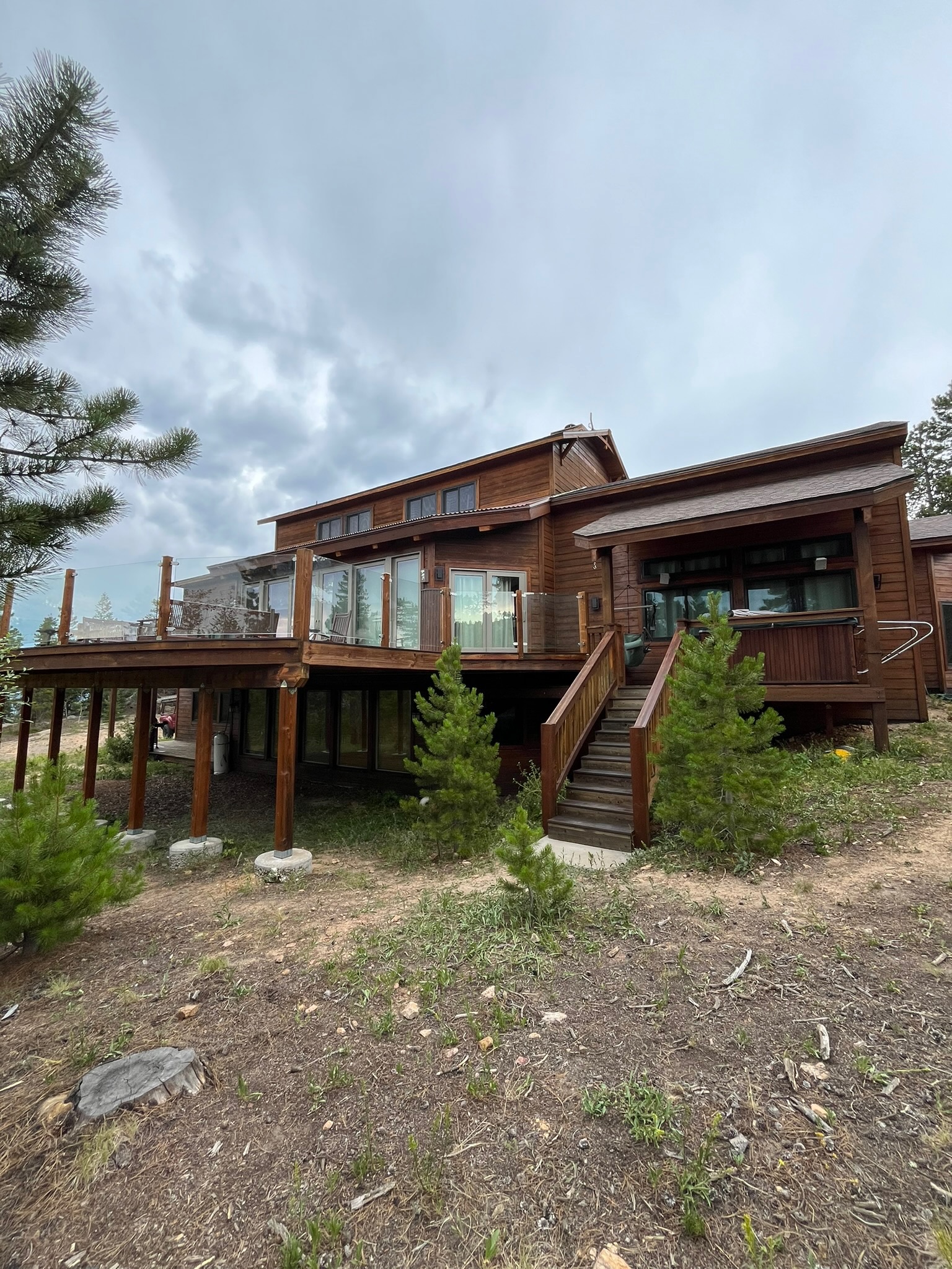 Mountain cabin exterior with stained wood and glass railing deck